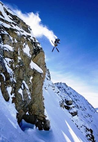 skiing skier going over a cliff