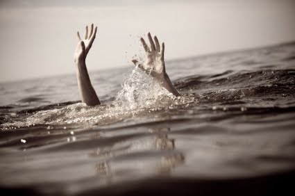 hands of drowning person reaching above water