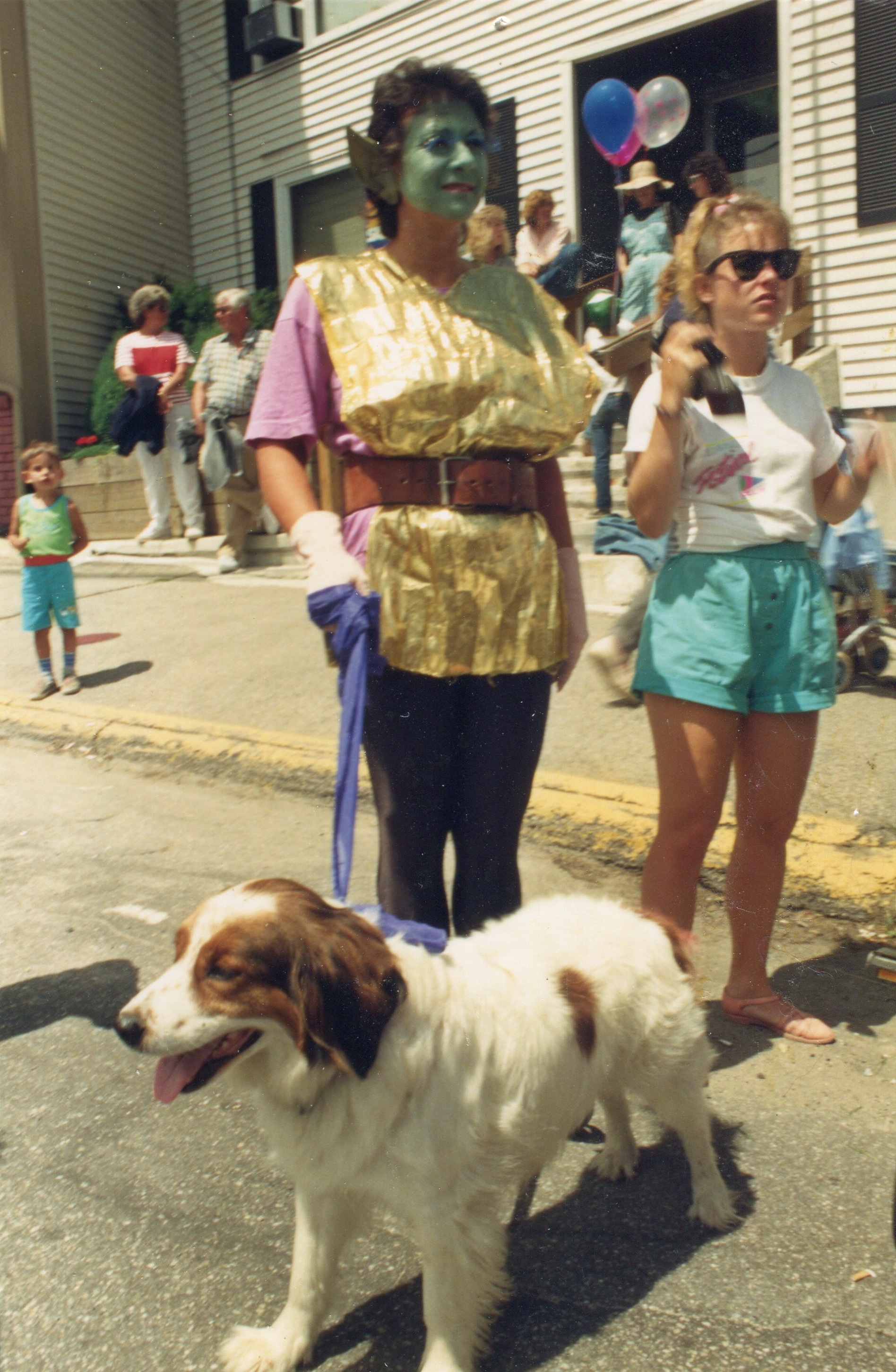 woman with elf make up on and  holding a dog on a leash